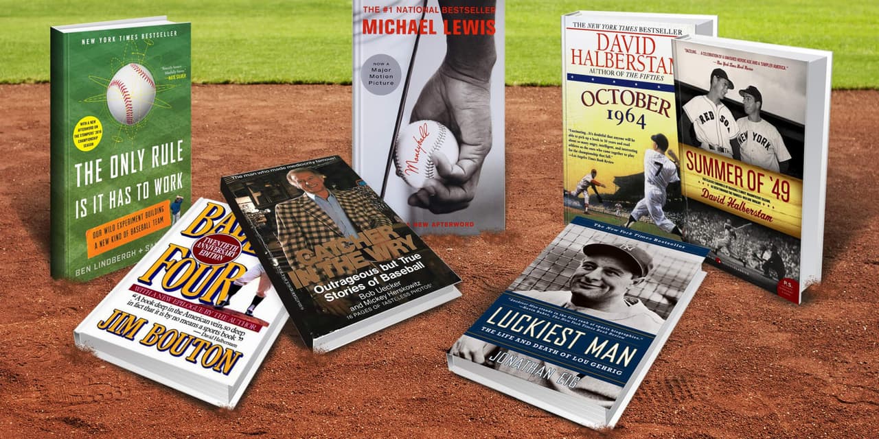 Stack of classic baseball books with worn gloves and baseballs on a wooden bench