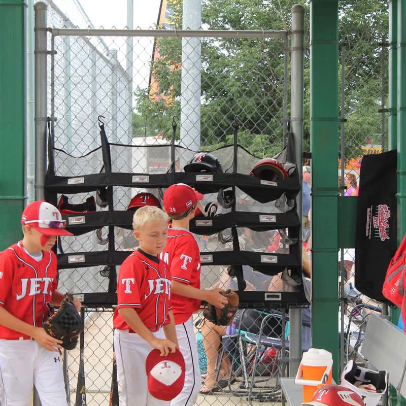 Organized youth baseball dugout with bats, helmets, and gear neatly arranged