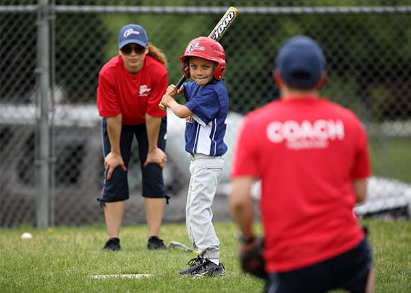 New youth baseball coach giving instructions to players on field