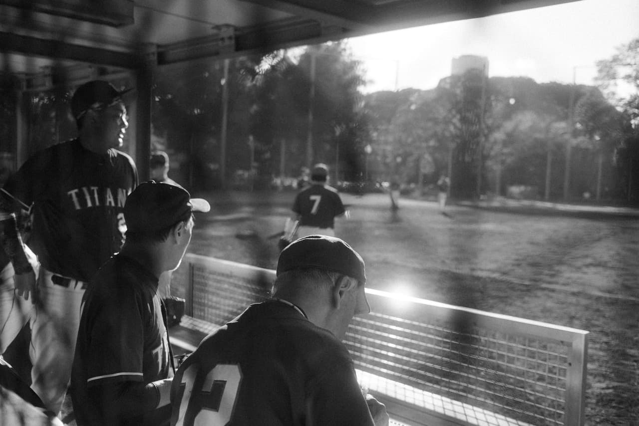 Coach scoring a baseball game on a tablet in the dugout