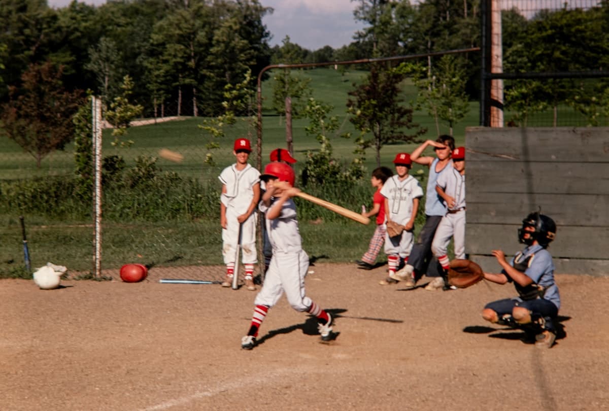 Youth baseball player at bat during a game, demonstrating proper swing mechanics