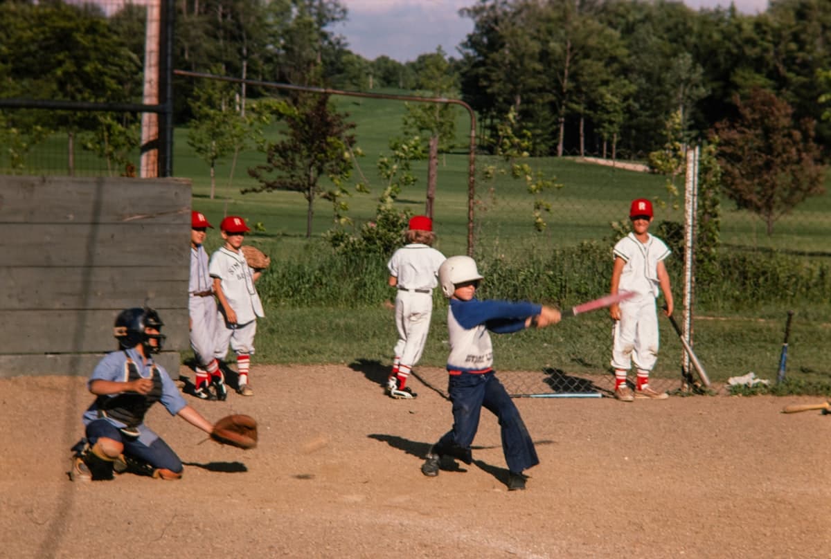 Youth baseball team during a game, players ready in the dugout and on the field