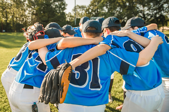 Youth baseball coach reviewing practice plan with team during pre-practice huddle