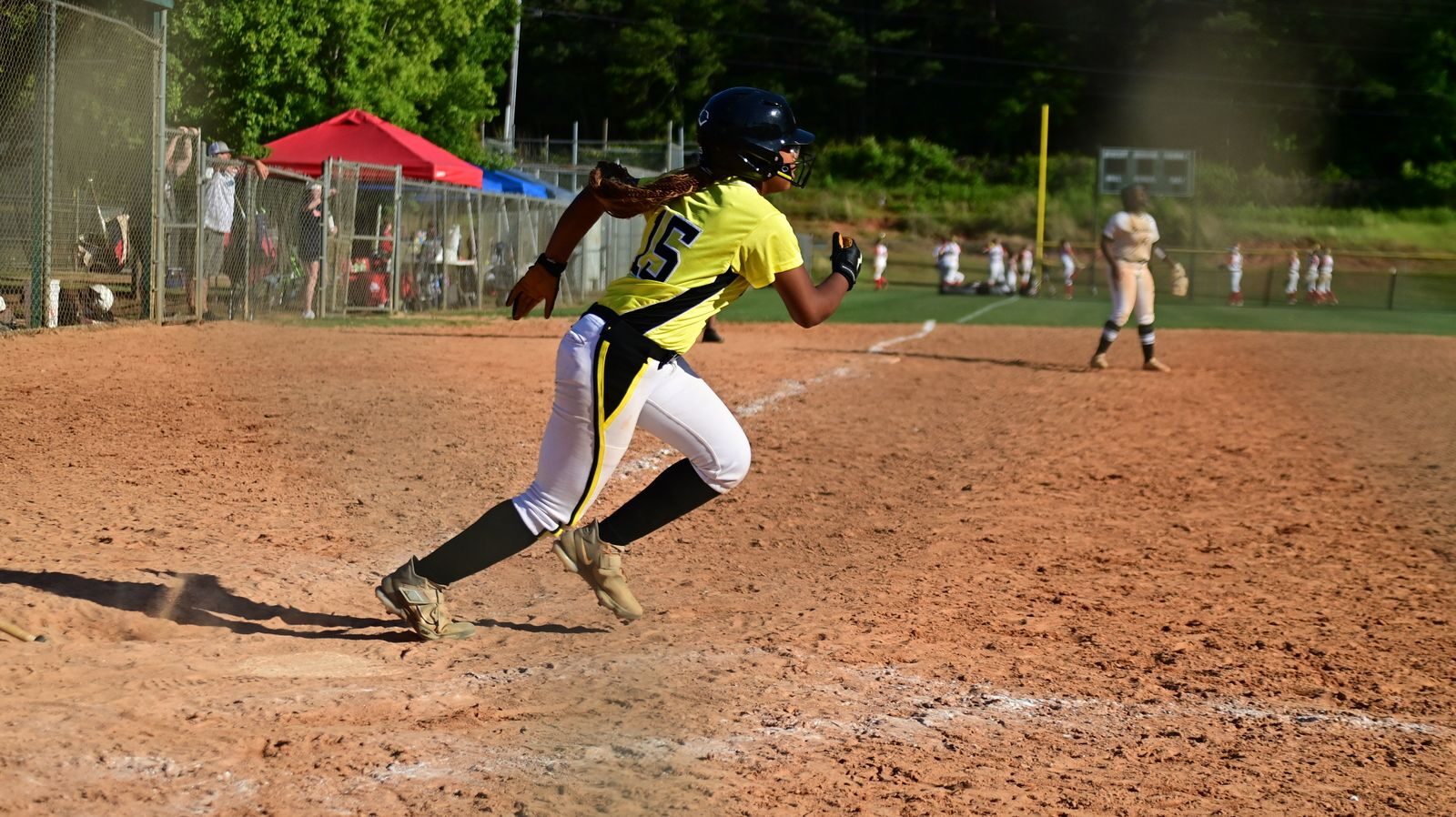 Youth baseball player sprinting up the base line during a game