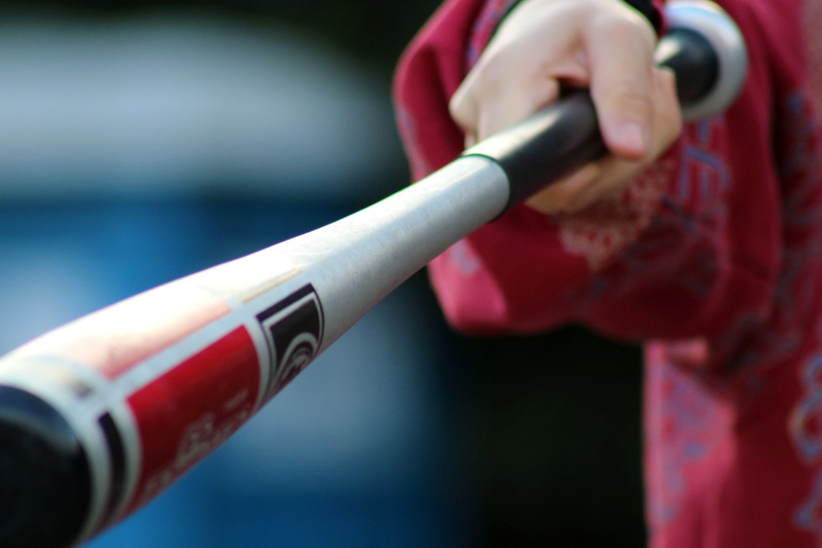 Close-up of a hitter's hands gripping an aluminum baseball bat