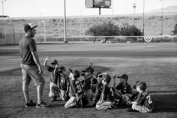 Beginner youth baseball coach teaching kids basic drills and skills
