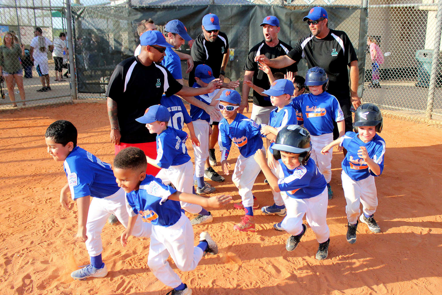 First-time youth baseball coach teaching fundamentals to young players on practice field
