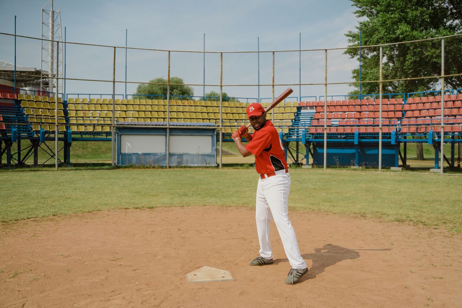 A hitter takes swings on the field to gauge bat performance during a fitting