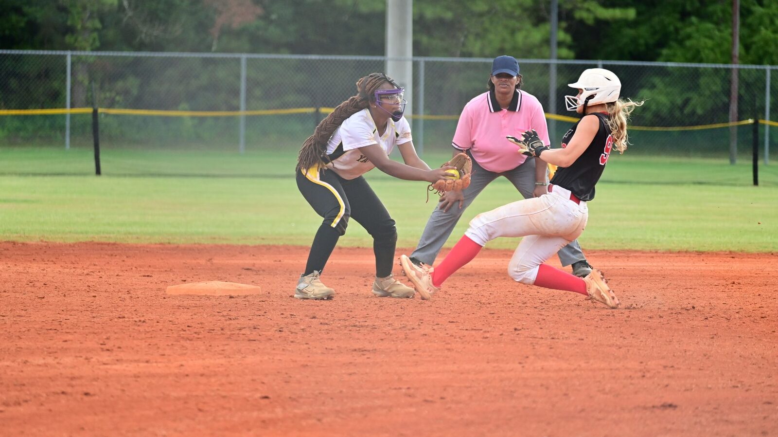 Close play at second base as the runner slides in ahead of the tag