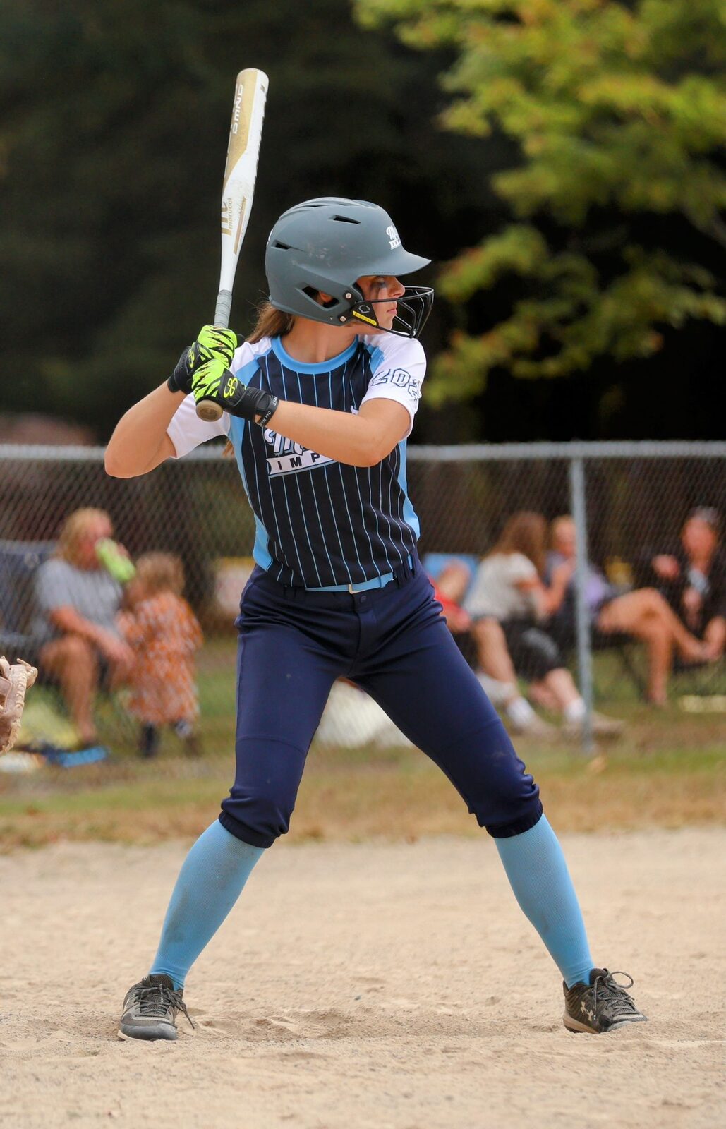Fastpitch softball player holding a bat to check length and fit