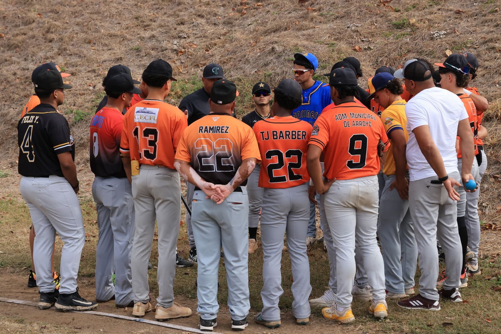 Youth baseball team gathered in a huddle before taking the field